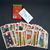 Baralho Cigano Lenormand da Rosalinda da Matta, com cartas expostas e embalagem em fundo escuro.