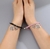 Dúo de pulseras araña negro y rosa de imán