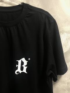 Camiseta preta básica de algodão com estampa em silk branca da letra B estilizada no peito, modelo regular.