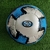 Bola de futebol Trivella C11 Pro para campo, com design moderno em azul e preto.