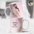 Caneca personalizada com ilustração de mulher e flores, com a frase "Ela ousa, Ela faz acontecer".