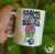 Caneca Gino Sincero com a frase "Comigo não tem essa de acordar cedo e ser simpática" e uma ilustração divertida de um personagem com óculos e touca.