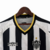 Camisa retrô do Atlético Mineiro de 2003, com listras pretas e brancas, gola amarela e logo da Umbro.