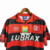 Camisa retrô do Flamengo de 1995 com listras vermelhas e pretas, fabricada pela Umbro e patrocinada pela Lubrax.
