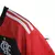 Camisa feminina do Flamengo, temporada 2023/24, com listras vermelhas e pretas, logo da Adidas e do clube na parte frontal.