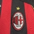 Camisa retrô do AC Milan da temporada 2006/07, com listras vermelhas e pretas, logo da Adidas e patrocinador Bwin.