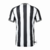 Camisa de futebol masculina do Newcastle United para a temporada 2023/24, com listras verticais pretas e brancas.