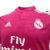 Camisa retrô do Real Madrid II 2014-15, na cor rosa, com logo da equipe e patrocínio da Fly Emirates.
