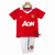 Conjunto infantil retrô do Manchester United, com camisa vermelha e calção branco, estampado com logo do time.