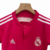 Conjunto infantil retrô do Real Madrid 2014/15, composto por camiseta rosa e shorts.