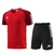 Conjunto Adidas composto por camisa vermelha com detalhes em marrom e shorts pretos, ambos com listras brancas.