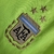 Detalhe do emblema da Seleção Argentina de Futebol em uma camisa goleiro verde, apresentando bordados em dourado e detalhes em azul. O design inclui estrelas que simbolizam conquistas da equipe.