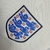 Emblema da seleção de futebol da Inglaterra, com três leões azuis em um fundo branco, adornados com rosas vermelhas. O design destaca a rica herança e tradição do futebol inglês, refletindo a paixão dos torcedores.