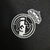 Logotipo do Real Madrid em preto e branco, com uma coroa acima, destacado em uma camisa retrô de manga longa. A camisa é predominantemente escura, realçando o design clássico e elegante do emblema do time.