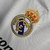 Detalhe do bordado do escudo do Real Madrid em uma camisa retrô de manga longa da temporada 2010/11.