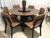 Conjunto Mesa Jantar Redonda 1,35m Base Preta com Tampo Madeira FIRENZE + 6 Cadeiras no Couro Sintético e Madeira Preta