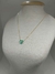 Encante-se com a beleza singular deste deslumbrante colar dourado, uma semijoia que combina elegância e estilo de forma única. Este exuberante acessório apresenta um delicado ponto de luz em formato de coração, adornado por uma deslumbrante pedra verde qu