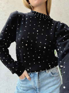 Suéter Cuarzo de color negro con detalles de perlas brillantes, combinado con jeans de tiro alto.