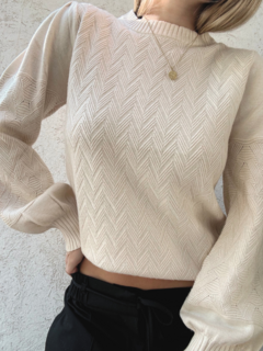 Sweater beige de largo medio, con diseño en espiga en delantera y mangas. Mangas abullonadas.