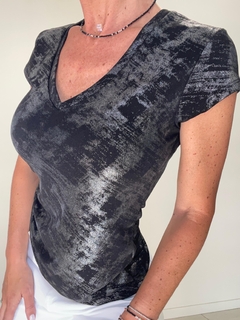 Remera Laurel de color negro con un diseño sutil, escote en V y mangas cortas, presentada en un entorno luminoso.