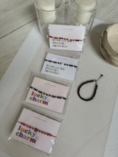 Variedad de pulseras de cristal en diferentes colores y diseños, presentadas en un entorno elegante con velas y accesorios.
