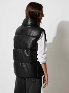 Chaleco engomado Negro largo. Con cuello alto y bolsillos. Cierre frontal con cremallera y botones
