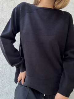 Sweater negro largo con detalles en los hombros y doble línea en la parte inferior.
