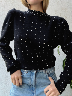 Suéter Cuarzo de color negro con detalles de perlas brillantes, combinado con jeans de tiro alto.