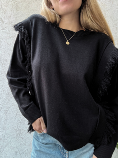 Sweater corte ancho y cuadrado, con detalles de flecos a los laterales y frunce en el cuello y mangas. Color Negro