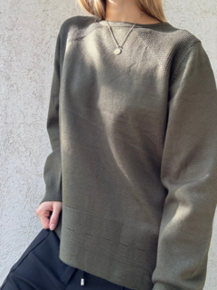 Sweater verde largo con detalles en los hombros y doble línea en la parte inferior.
