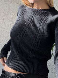 Sweater negro con detalle de trenzas en la parte delantera y mangas. Cuello semi alto, y frunce en la parte inferior. Espalda lisa
