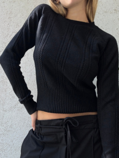 Sweater negro con detalle de trenzas en la parte delantera y mangas. Cuello semi alto, y frunce en la parte inferior. Espalda lisa