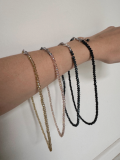 Collares de cristal en diferentes colores sobre un brazo.