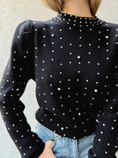 Suéter Cuarzo de color negro con detalles de perlas brillantes, combinado con jeans de tiro alto.