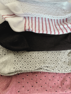 Conjunto de medias cortas en diferentes colores y patrones, incluyendo blanco, negro y gris.