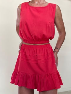 Top de lino color rojo con falda de volados, modelo femenino en un entorno neutro.