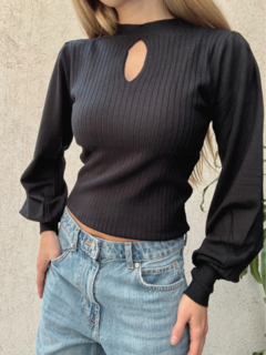 Sweater negro ajustado, con diseño de canalé y un corte en forma de lágrima en el escote. Mangas globo
