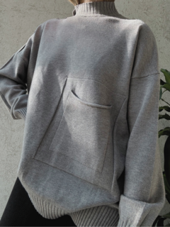 Sweater gris largo. Cuello alto y bolsillo frontal. Detalle de línea en los hombros y puños con frunce.