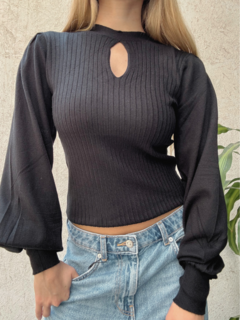 Sweater negro ajustado, con diseño de canalé y un corte en forma de lágrima en el escote. Mangas Globo