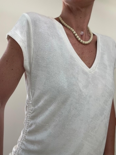 Remera de color blanco con escote en V y detalles fruncidos en los costados.
