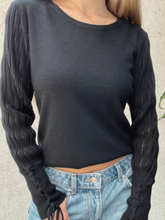 Sweater negro de lana liso, con mangas anchas y detalle de transparencias. Puño con detalle de trenzado.