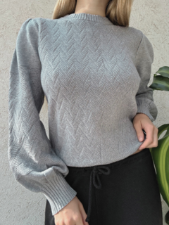 Suéter gris de mujer con diseño en espiga y mangas abullonadas.