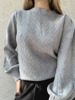 Sweater gris de largo medio, con diseño en espiga en delantera y mangas. Mangas abullonadas.