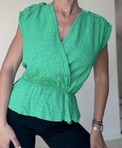 Blusa verde con mangas cortas y cintura ajustada, presentada de perfil.