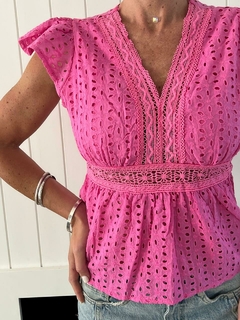 Blusa coco de color rosa con detalles de bordado y mangas cortas, combinada con pantalones cortos de denim.