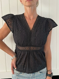 Blusa negra con mangas acampanadas y detalles de encaje, ideal para un look casual y elegante.