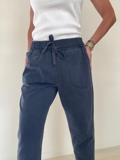 Pantalón Serena de color gris oscuro con cintura elástica y bolsillos laterales, modelo de moda.