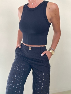 Pantalones Palazzo Marfil de Zara, color negro, con detalles perforados y una blusa sin mangas a juego.