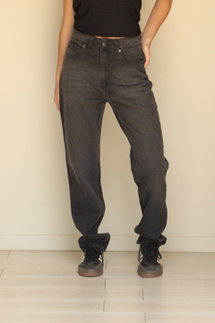 Pantalones de jean color negro, con un ajuste relajado, llevados por una modelo que posa de pie.