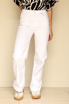 Pantalones de mezclilla blancos con corte recto, combinados con una blusa de estampado negro y blanco.